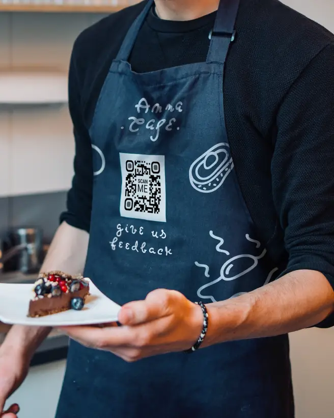 Close-up of a person wearing an apron with a QR Code on it.