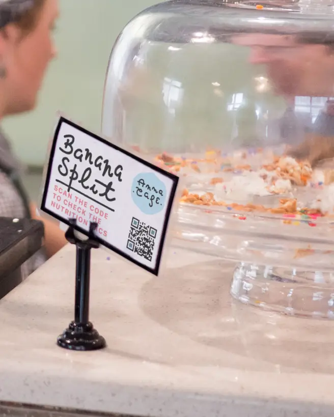 A cafe tabletop display card with a qr code on it.