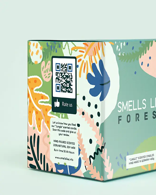 Closeup of a blue candle box with colorful leaves and a rating QR Code on it next to a candle jar.