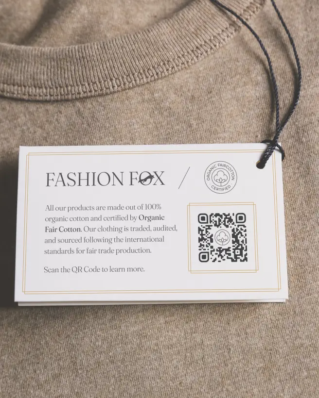 A clothing label tag that describes the sources and materials of the garment. A QR Code can be scanned to learn more.
