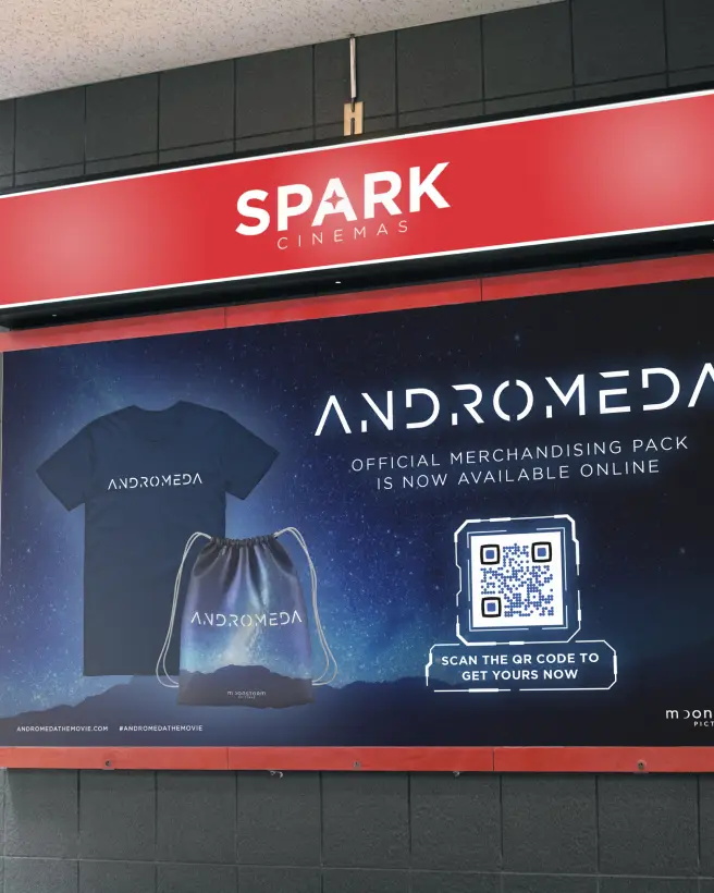 Movie poster ad with a tshirt and drawstring backpack on it and a QR Code to scan to get movie merchandise online.