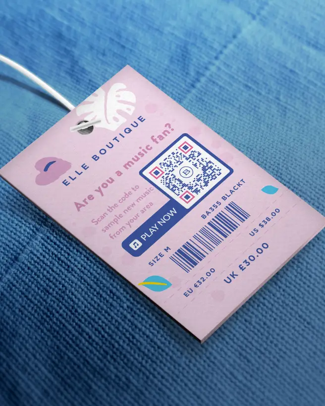 Close up of a piece of blue clothing with a pink hang tag with a music qr code on it.