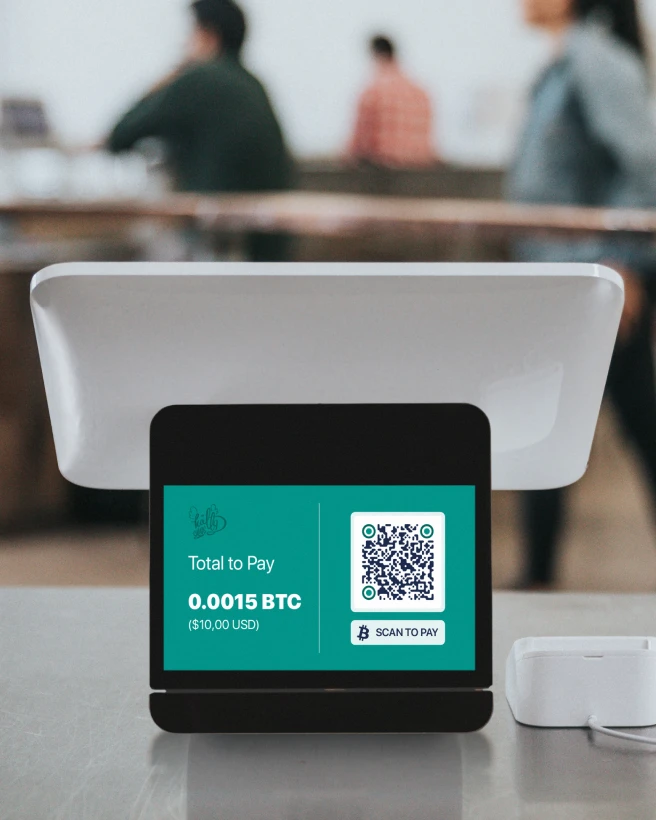 Cash register on a counter with a tablet displaying a payment QR Code.