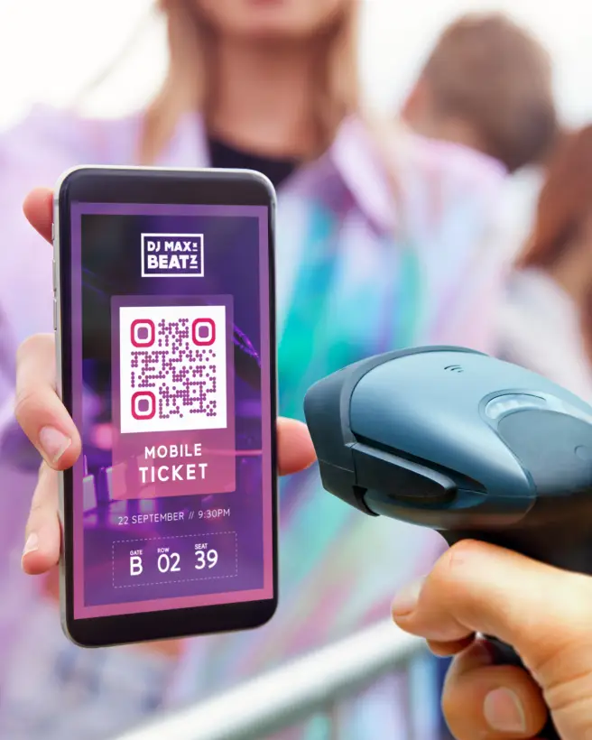 A hand with a scanner tool that is scanning a QR Code ticket on a mobile phone.