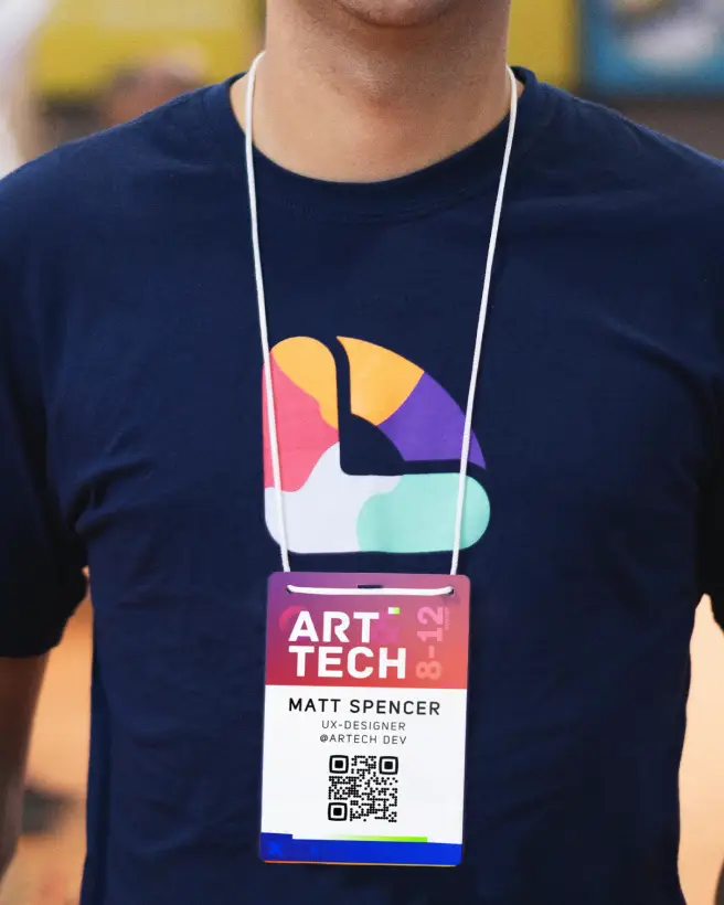 A man wearing a t-shirt and an event badge with a QR Code.